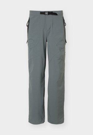 Grå udendørsbukser med justerbart sort bæltespænde, lynlåslommer i siderne og forstærkede knæpaneler, vist forfra på hvid baggrund.