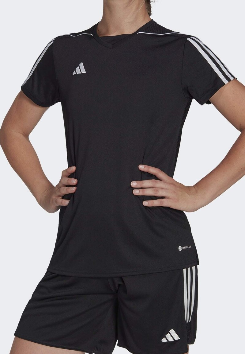 Camiseta deportiva negra de mangas cortas, con diseño de cuello en V, que presenta franjas blancas en los hombros y el logo de adidas en el pecho.