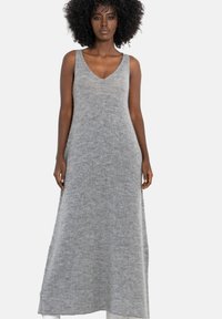 Szara dzianinowa sukienka z dekoltem w kształcie litery V, bez rękawów, o luźnym kroju i miękkiej, fakturowanej tkaninie. Długość do połowy łydki.