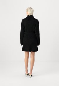Black, fluffy coat dress with long sleeves, high collar, and belted waist. Features textured fabric and a slightly flared hemline.