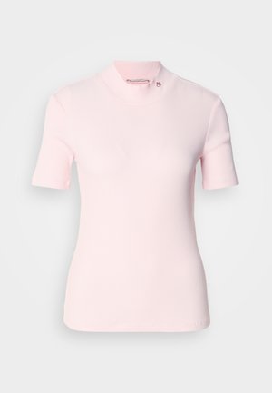 Top corto a maniche corte di un delicato rosa pallido con un collo alto a mock neck e un sottile logo sul colletto. Tessuto morbido con un design aderente.