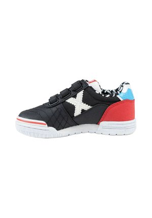 Zapatilla negra, roja y azul con suela blanca, tres correas negras, X blanco cosido en el lateral y forro interior estampado.