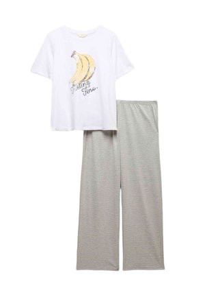 Biała koszulka z krótkim rękawem z żółtą grafiką banana i napisem „Feeling Fine”, zestawiona z szerokimi spodniami w szaro-białe paski.