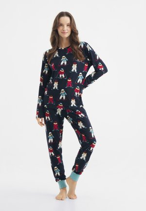 Navy pyjamabroek met lange mouwen en broek, met een patroon van skiers in verschillende kleuren. De manchetten hebben een effen mintgroene accent.