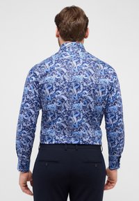 Langarmshirt met een blauw paisleypatroon op een marineblauwe achtergrond, gemaakt van een soepele stof met een klassieke kraag en knoopmanchet.