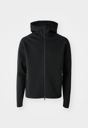 Felpa nera con zip e colletto alto, realizzata in morbido tessuto texturizzato. Presenta tasche laterali e linee di design eleganti sulle maniche.
