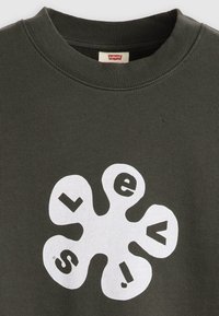 Dark green sweatshirt with a white graphic design resembling flower petals, featuring the text "LEVI'S!" in a circular pattern.