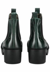 Stivaletti alla caviglia in pelle verde con finitura liscia, dotati di pannelli laterali elastici, un tacco nero spesso e un piccolo dettaglio con logo a forma di ape.
