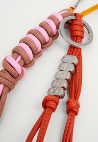 Multicolored keychain with brown and pink woven material, a silver ring, and red leather detailing featuring silver letter accents spelling "PINKO."