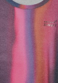 Svetr s gradientovými pruhy v odstínech fialové, růžové a oranžové; má kulatý výstřih a text "sunset" ve stříbrném kovovém provedení. Měkká textura.