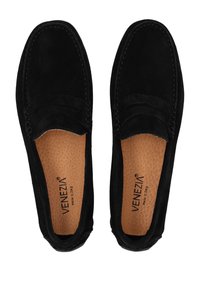 Czarne zamszowe buty slip-on w stylu mokasynów, z detalami w postaci przeszyć i teksturowaną wkładką. Wnętrze oznaczone "Venezia, Made in Italy."