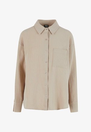 Beige Hemd mit Knopfverschluss aus strukturiertem Stoff mit zerknittertem Aussehen. Verfügt über einen Kragen, lange Ärmel und eine einzelne Brusttasche.