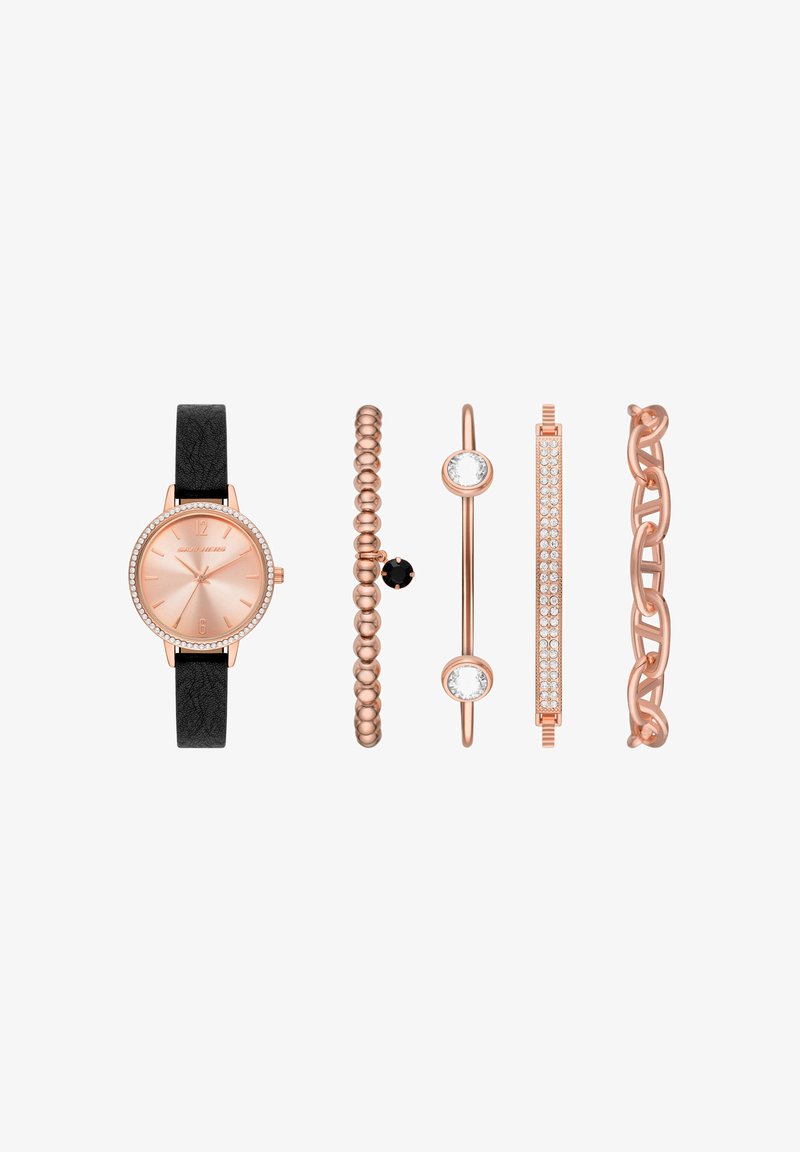 Montre en or rose avec bracelet noir et quatre bracelets en or rose, composés de perles, pierres noires et transparentes, et motifs de chaînes liées sur fond blanc.