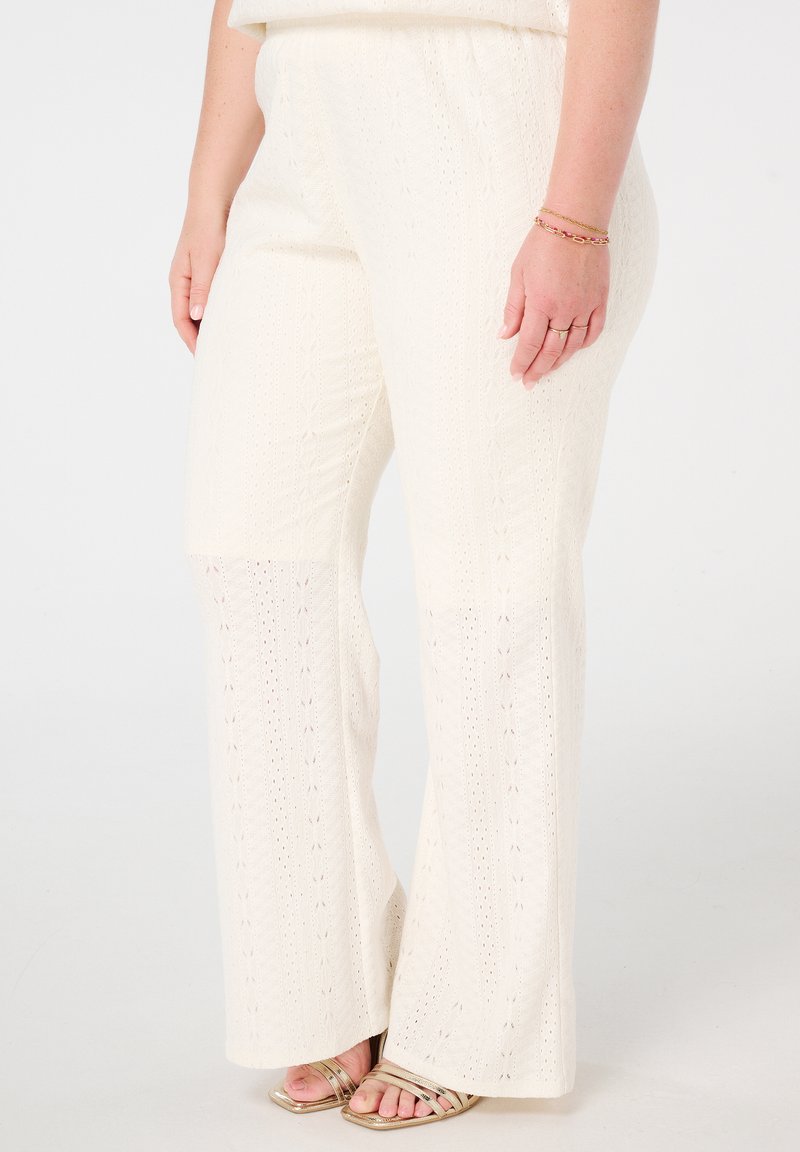 Pantalons larges en tricot de couleur crème, avec un motif texturé, dotés d'une taille élastique et de découpes subtiles en forme de dentelle.