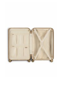 Harde koffer in crème met gouden accenten, voorzien van meerdere binnenzakken, een crossband om items te beveiligen en vier wielen.
