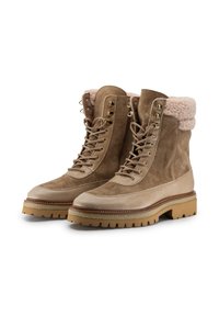 Stivali in suede marrone chiaro con rivestimento in pelliccia sintetica, design con lacci e suola in gomma. Presentano una punta in pelle liscia e occhielli in metallo per i lacci.