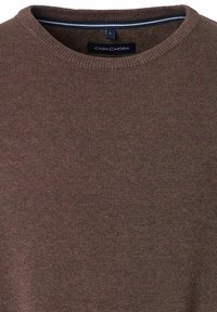 Bruine gebreide trui met een geribbelde textuur, met een ronde halslijn. Label zichtbaar aan de binnenkant van de kraag met de tekst "CASA MODA," maat L.