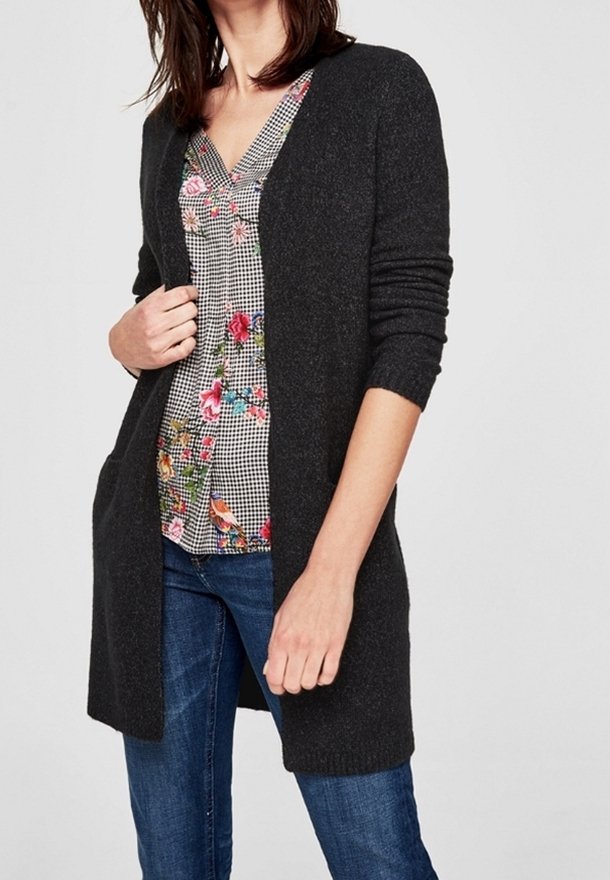 Cardigan lungo grigio realizzato in morbido materiale a maglia, con apertura frontale, maniche lunghe e due tasche frontali. Indossato sopra una maglietta con motivo floreale.
