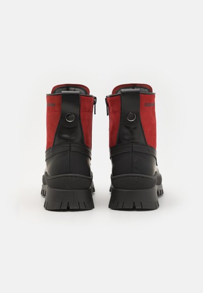 Røde semskede og sorte læder ankelstøvler med en kraftig gummisål, der har lynlåslukning og runde hardware-detaljer.