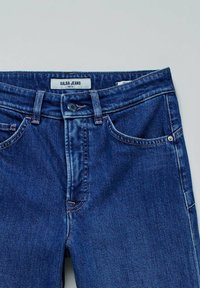 Džínové kalhoty v tmavě modré barvě. Klasický design s pěti kapsami a zapínáním na knoflík. Na štítku je nápis "Salsa Jeans Faith." Texturovaná tkanina s jemným prošíváním.