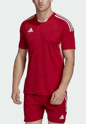 Maglia sportiva rossa con maniche corte, scollo a V e un motivo geometrico. Presenta strisce bianche sulle spalle e il logo Adidas.