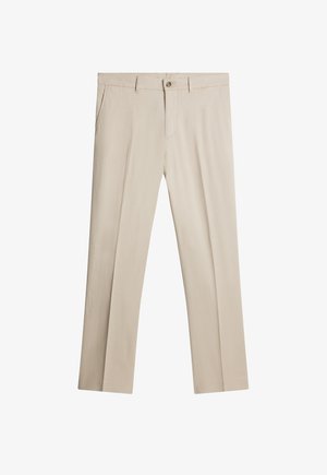 Pantalones beige a medida de tejido ligero, con frente plano, bolsillos laterales y cierre de un solo botón. Textura suave.