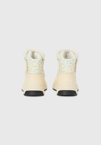 Beige wasserdichte Stiefel mit gemusterten mintgrünen und orangefarbenen Akzenten, weicher Fütterung, strukturiertem schwarzen Sohle und erhöhtem Absatz. "SOREL"-Logo an der Ferse.
