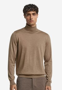Rollkragenpullover in einem hellbraunen Farbton, aus feinem Strickmaterial gefertigt, mit langen Ärmeln und geripptem Saum und Kragen.