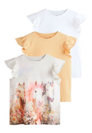 Trzy dziewczęce topy z falbanami na rękawkach w kolorach: biały, beżowy i żółty; beżowy top ma kwiatowy wzór z trzema końmi na przodzie.