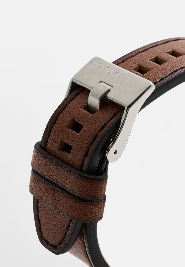 Brauner Lederarmband mit strukturiertem Finish, mit quadratischen Ausschnitten, schwarzem Rand und einer silbernen Metallschnalle mit dem "DIESEL"-Logo.