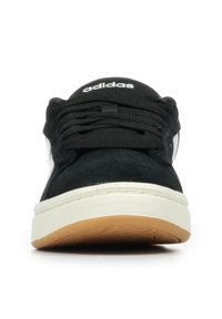 Czarne zamszowe sneakersy z białym logo adidas, okrągłym noskiem, sznurowanym przodem i beżową gumową podeszwą. Charakteryzują się gładką teksturą i prostym designem.