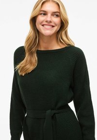 Ciemnozielony dzianinowy sweter z teksturowanym wzorem, długimi rękawami, okrągłym dekoltem i materiałowym paskiem zawiązanym w talii.