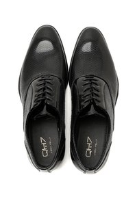 Scarpe eleganti da uomo in pelle nera con una texture perforata, design con lacci e dettagli in pelle lucida sulla punta e sul gambale.