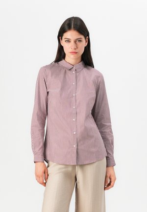 Chemise à manches longues avec un col boutonné, dotée de fines rayures verticales rouges et blanches, et d'une silhouette ajustée.