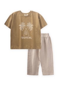 Tan spalvotų trumpų rankovių marškiniai su palmės medžio grafika ir užrašu "TROPICAL", derinami su šviesiai bežinėmis dryžuotomis kelnėmis su elastine juosta.