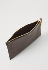 Bordeaux leren pouch met een gouden rits, met een gladde textuur en een minimalistisch ontwerp. Logo is in het leer gedrukt aan de voorkant.