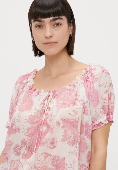 Blusa rosa claro com padrões florais, decote redondo, detalhe de cordão e acabamentos em babados nas mangas. Feita de um tecido suave e leve.