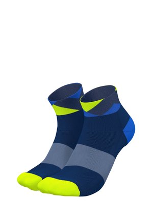 Kompressionssocken in Marineblau, Grau und Blau mit Neon-Gelb-Akzenten. Sie verfügen über ein geometrisches Muster und eine strukturierte Oberfläche. In der Länge bis zur Mitte der Waden.