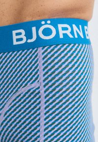 Colorful men's underwear featuring a blue elastic waistband with "BJÖRN BORG" text, and a striped pattern in varying blue and green tones.