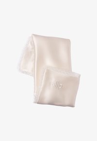 Funda de almohada de satén marfil suave con un delicado borde de encaje y "slip" bordado en una esquina, doblada cuidadosamente sobre un fondo blanco.