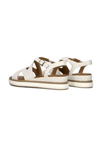 Witte leren sandalen met kruisbanden en een verstelbare gesp. Voorzien van een dikke, gevoerde zool met een bruin accent.