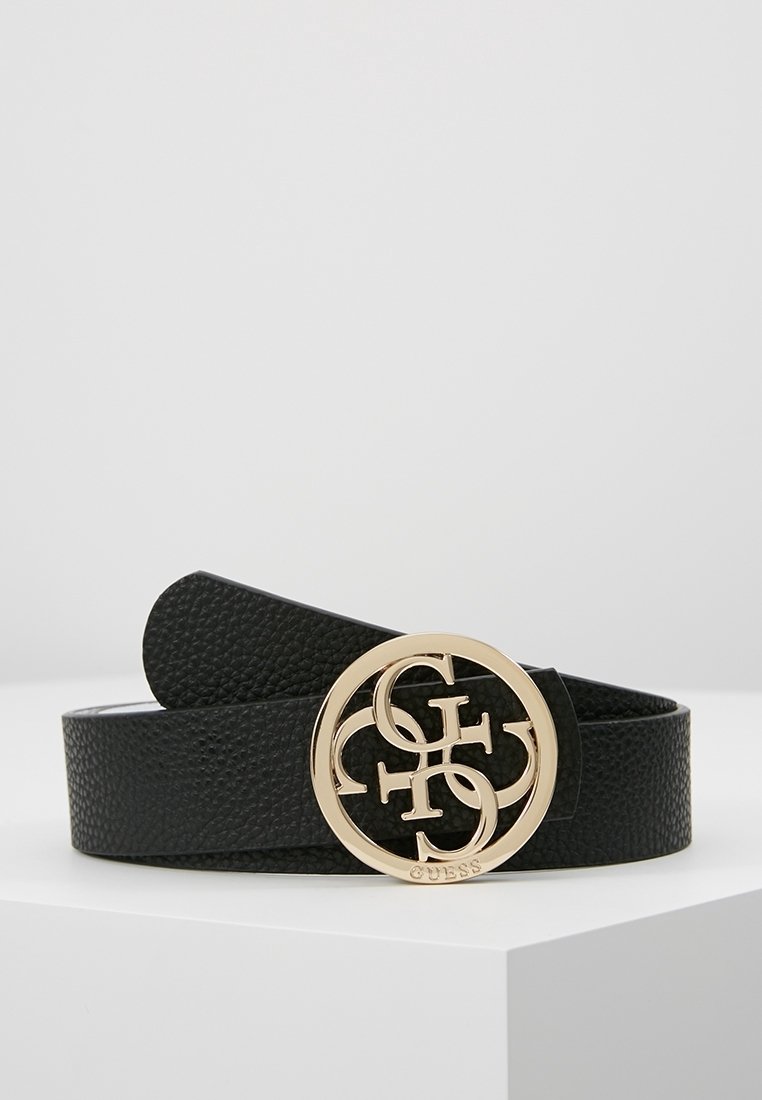Ceinture en cuir noir texturé avec une boucle ronde dorée présentant des lettres entrelacées et le nom de la marque "Guess" gravé.