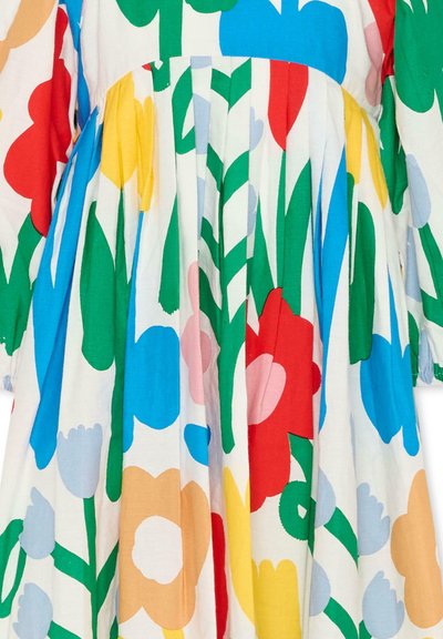 Tessuto a stampa floreale vivace con grandi fiori astratti in rosso, giallo, blu, pesca, rosa e verde su sfondo bianco, caratterizzato da dettagli plissettati.