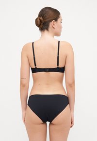Ensemble de bikini noir avec un design simple, featuring des bretelles réglables sur le soutien-gorge et une culotte taille basse, fabriqué dans un matériau lisse et extensible.