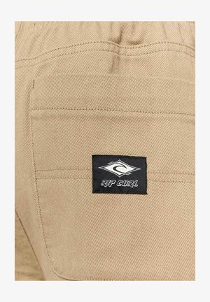 Khaki-Hosen mit einer Gesäßtasche mit einem schwarzen Rip Curl-Logopatch, glatter Textur und elastischem Bund für komfortablen Sitz.