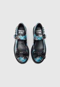 Crne i plavo karirane Mary Jane cipele s teksturiranim crnim mašnom sa srebrnim šiljcima, podesivom kopčom i debelim gumenim potplatima.