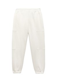 Licht beige joggerbroek gemaakt van zacht materiaal, met een elastische tailleband, twee zijzakken en taps toelopende boorden.