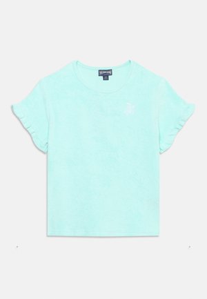 Lyseblå kortermet babykjorte med rysjer på ermene og liten hvit brodert skilpadde-logo på øvre venstre bryst.