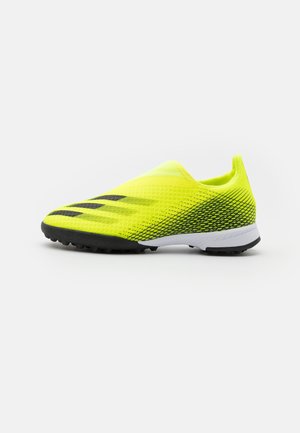 Chaussure de sport jaune vif avec une tige en mesh, des accents noirs et une semelle texturée conçue pour l'adhérence. Style léger et à enfiler.