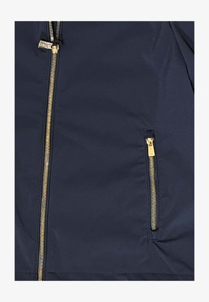 Tessuto blu navy con due cerniere verticali dorate, una più grande con linguetta di scorrimento e una più piccola per una tasca.